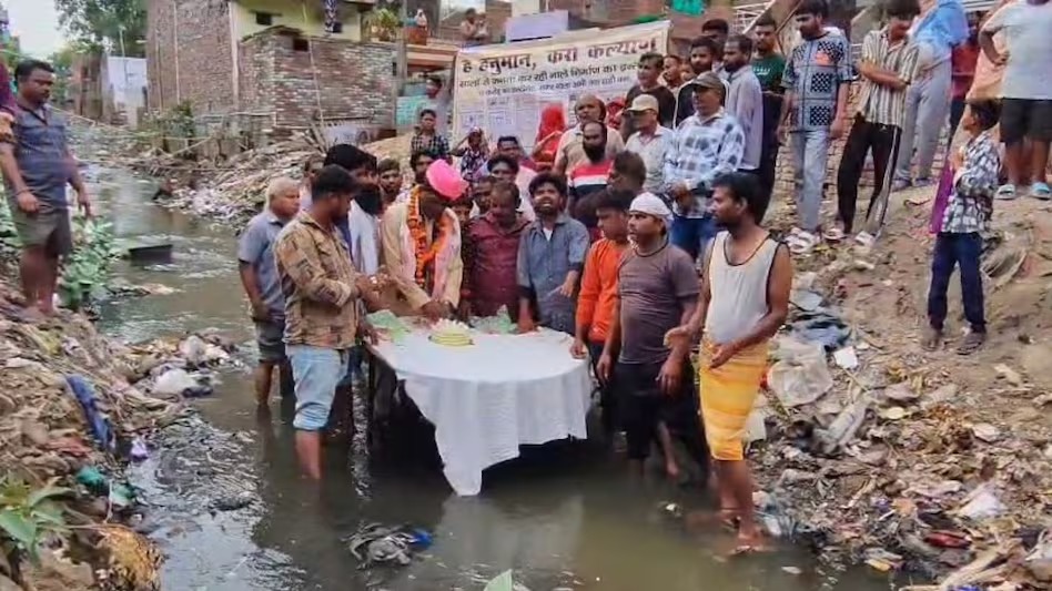 आगरा: BJP पार्षद का अनोखा विरोध प्रदर्शन, नाले में खड़े होकर काटा बर्थडे केक